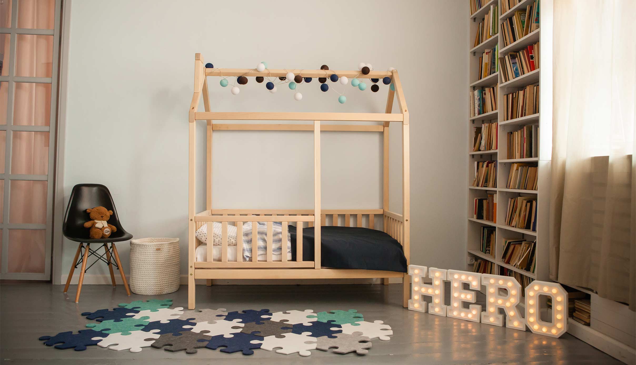 A child's room with a wooden bed and bookshelves.