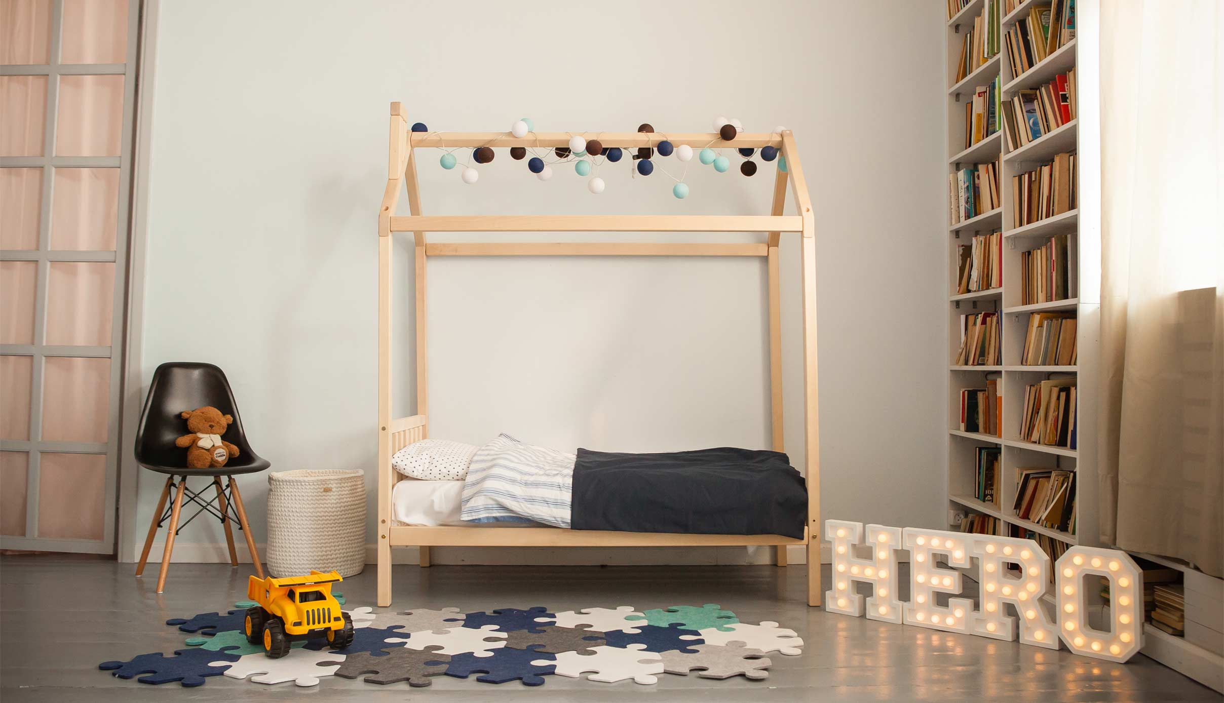 A child's bedroom with a wooden bed and bookshelves.