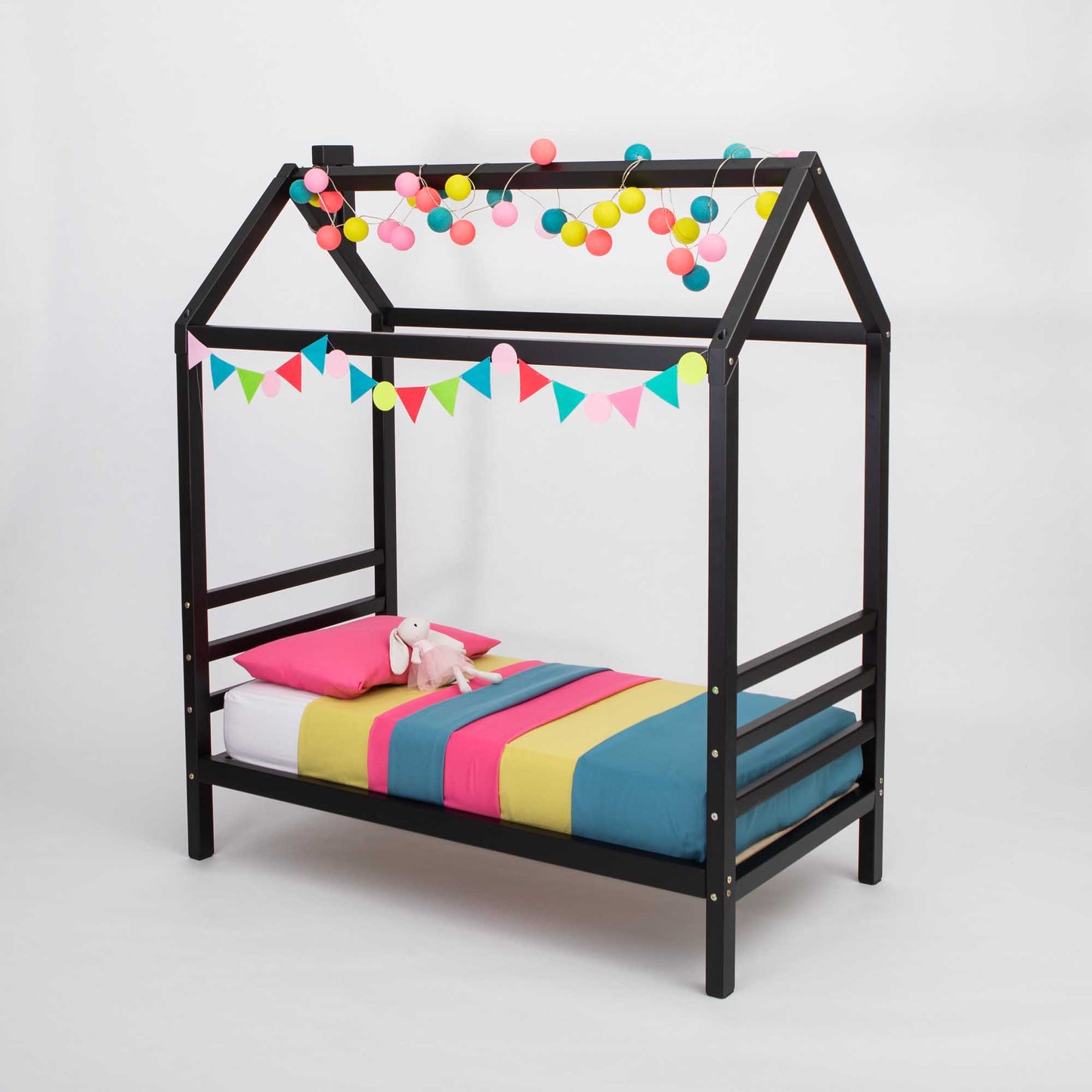 A Kids' house bed on legs with a headboard and footboard with a colorful canopy and bunting.