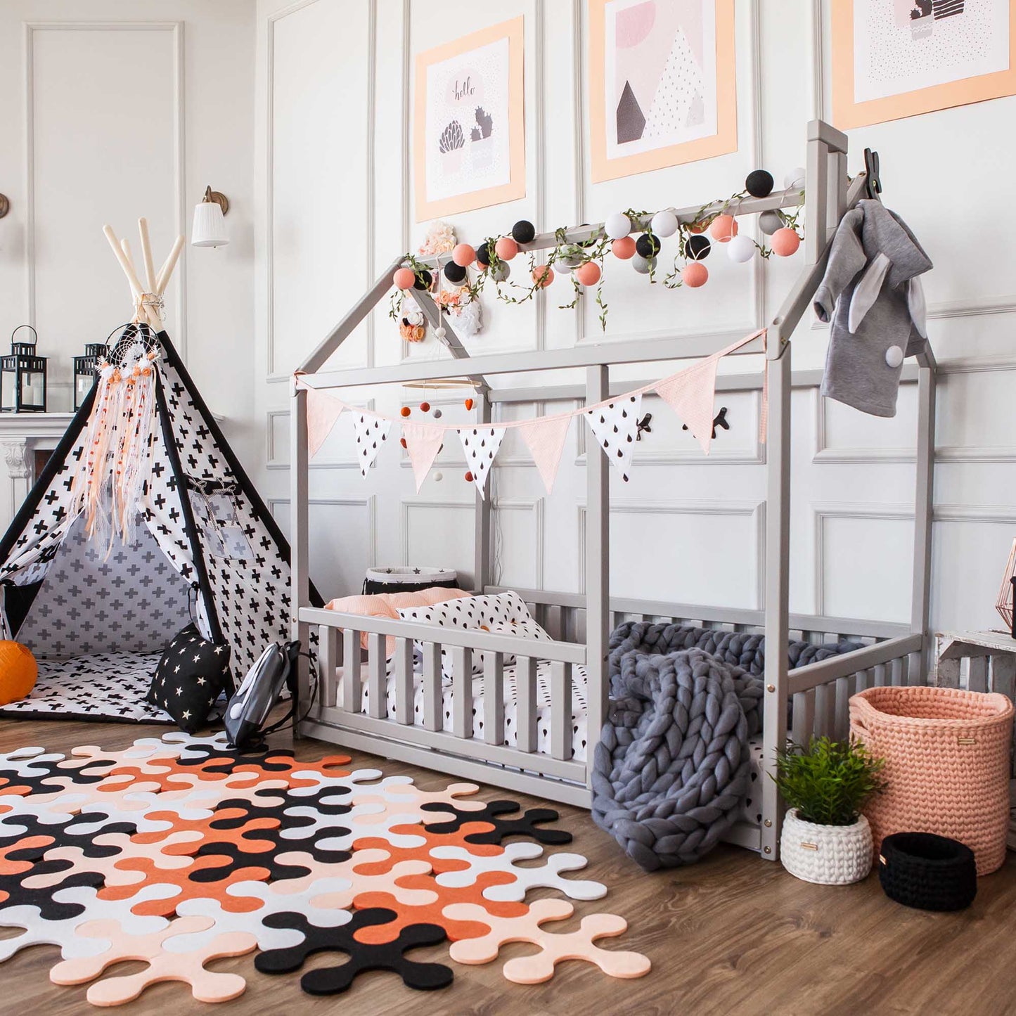 A cozy sleep haven for a baby, featuring a Montessori floor house bed with rails, polka dots, and a teddy bear from Sweet Home From Wood.