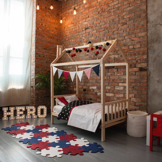 A child's bedroom with a Toddler house bed on legs with a headboard and footboard and a rug.