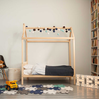 A child's room with a toddlers' house bed on legs with a headboard and toys.