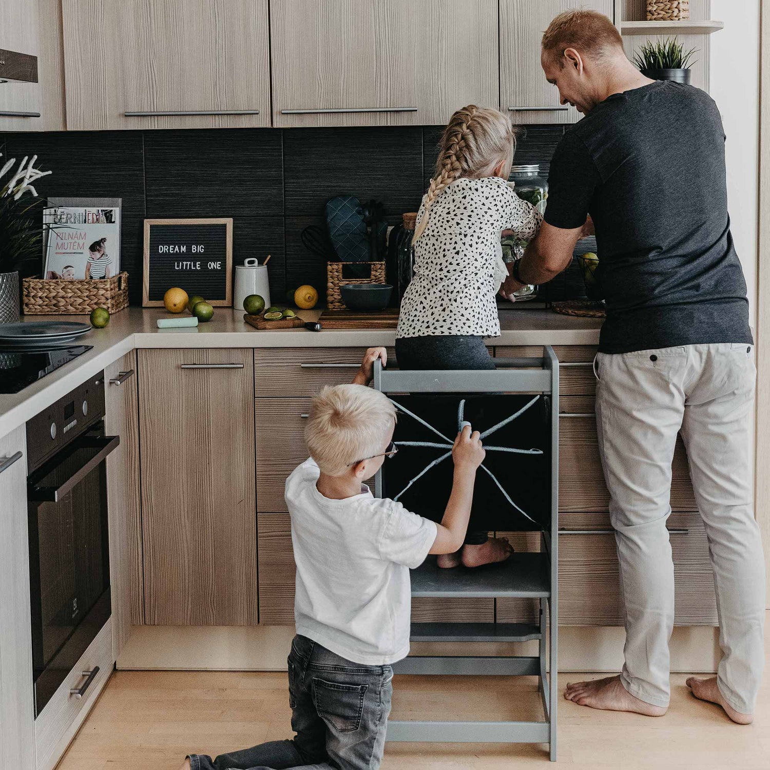 A man and a child in a kitchen preparing food.