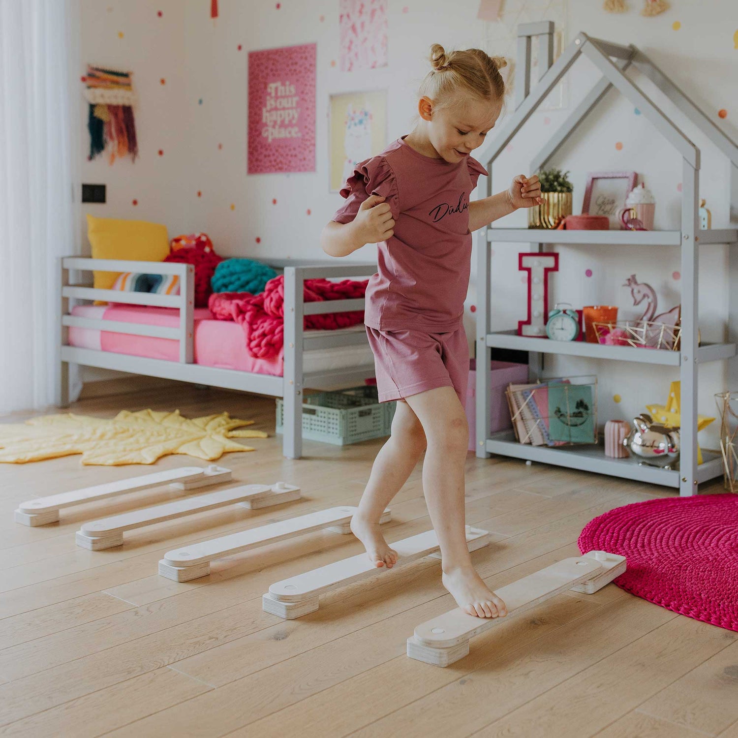 A little girl is playing with wooden blocks in her room.