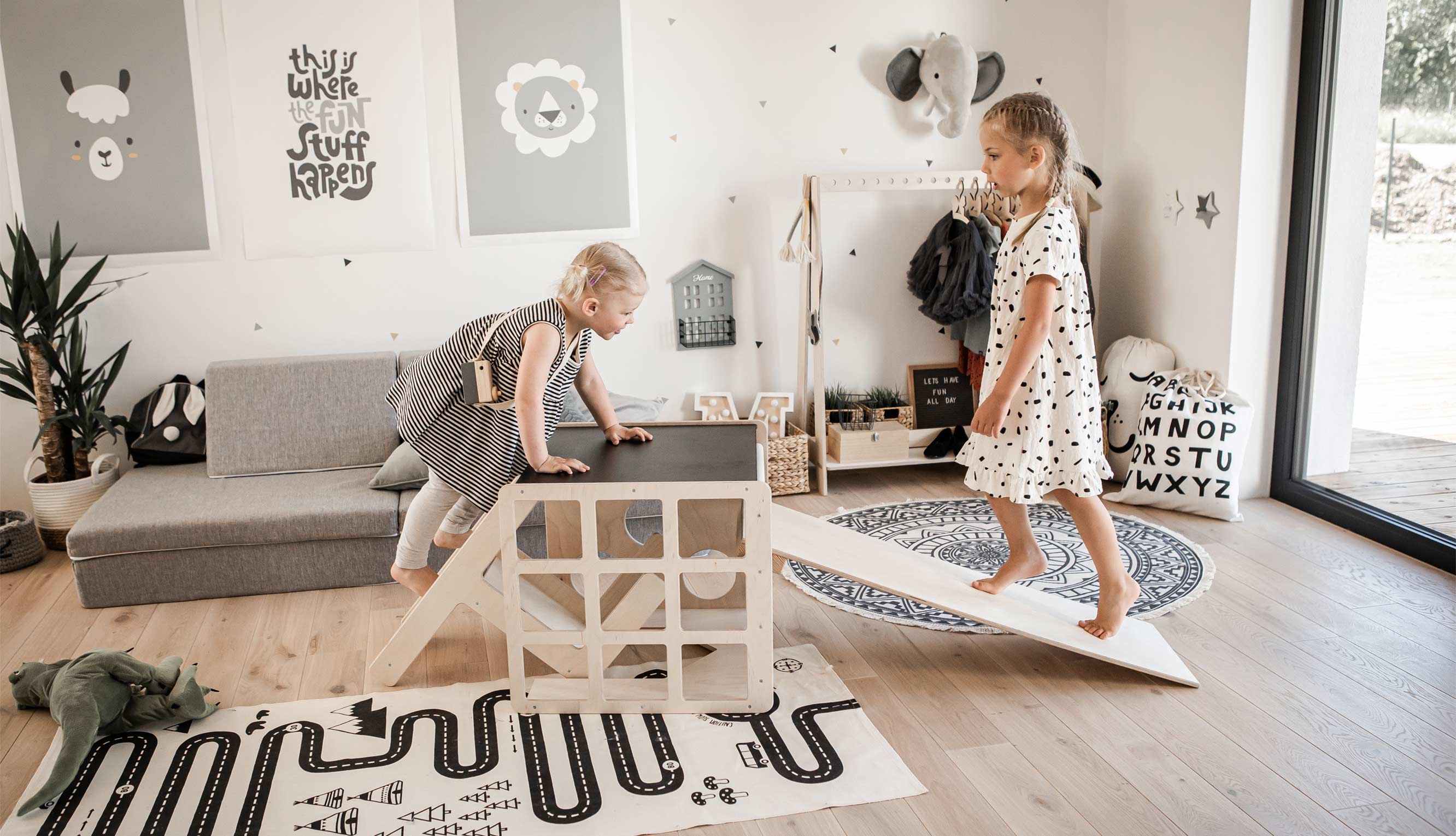 Two children playing in a room with a slide.