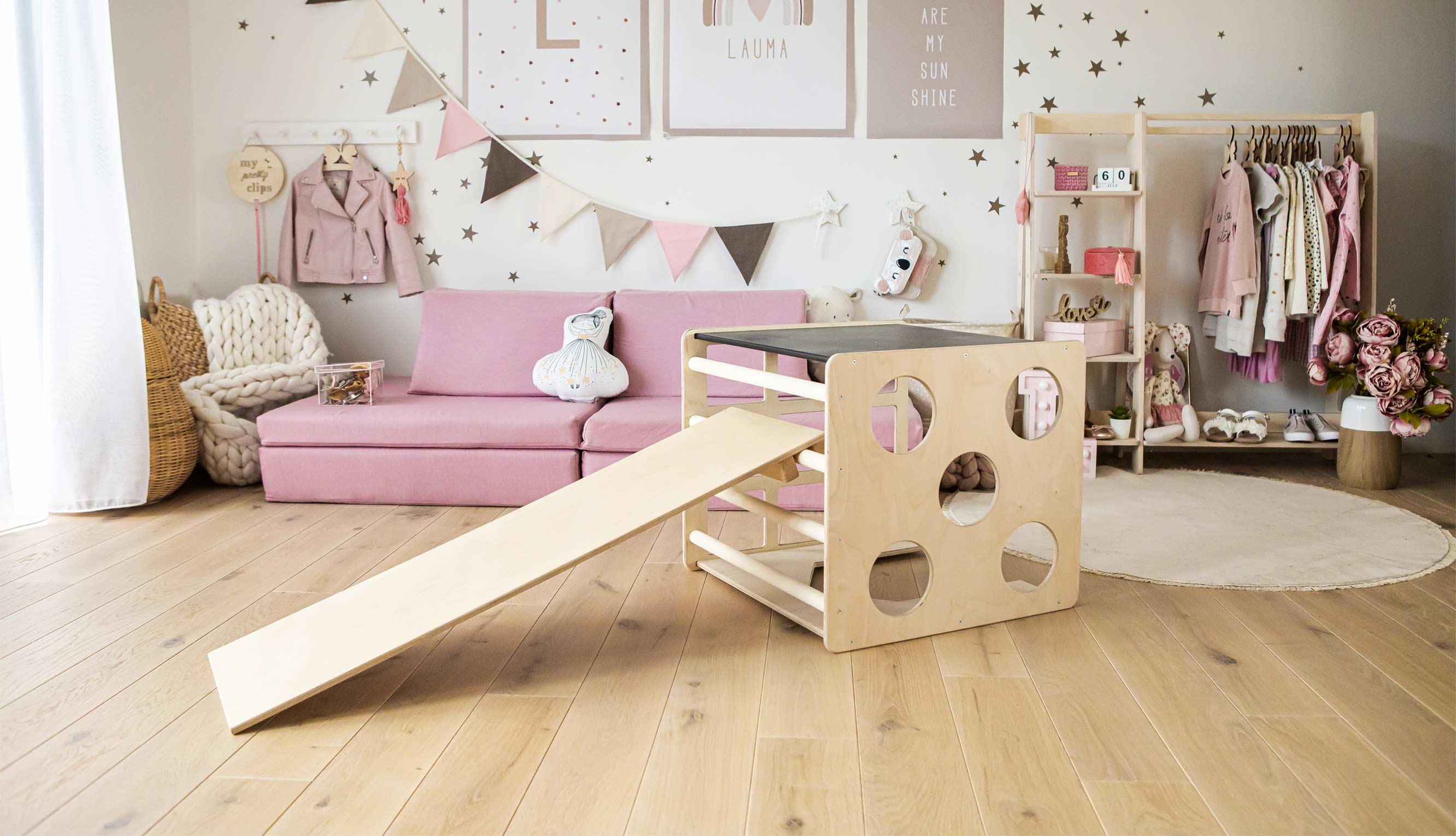 A children's room with a slide and a pink couch.