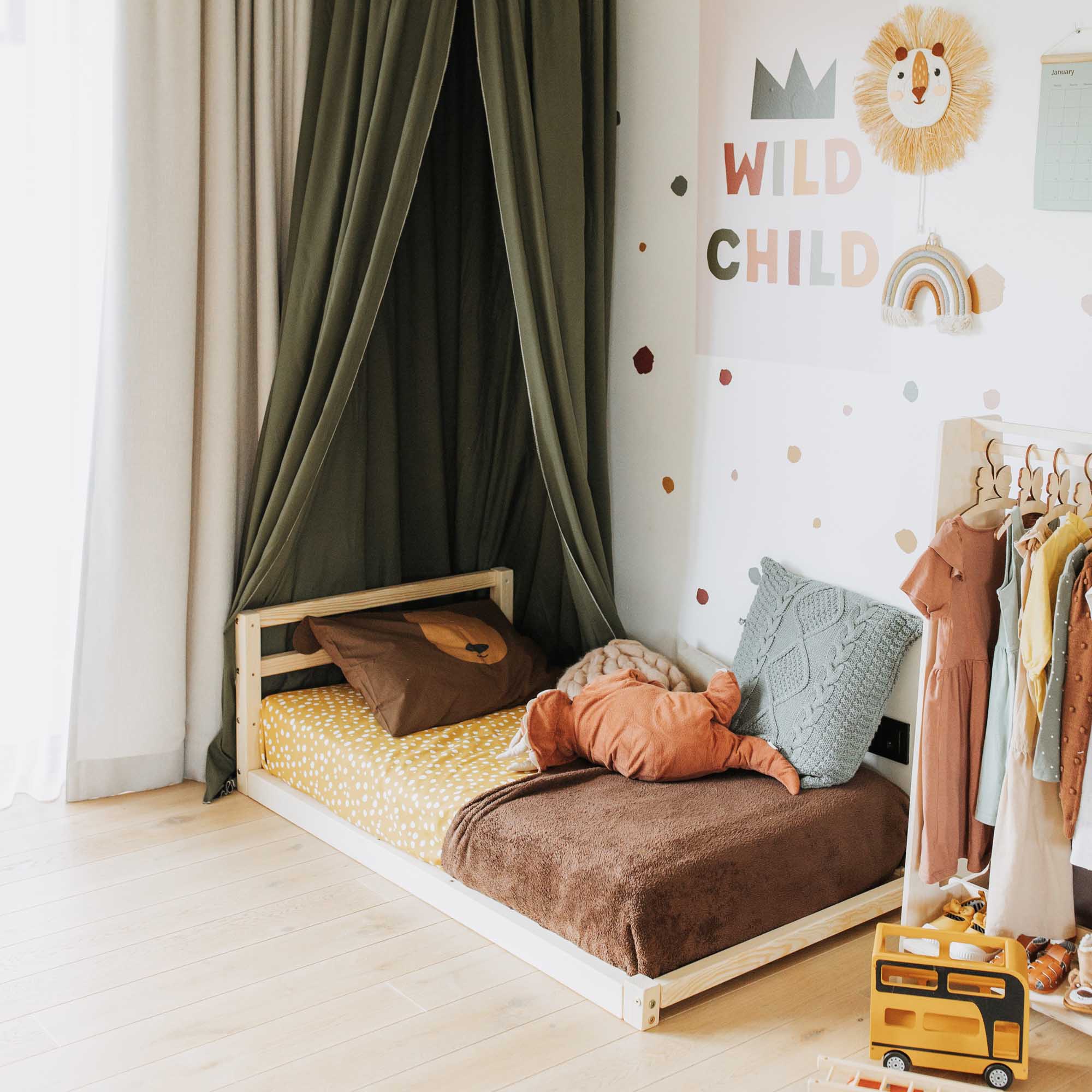 A child's room with a bed and a teddy bear.