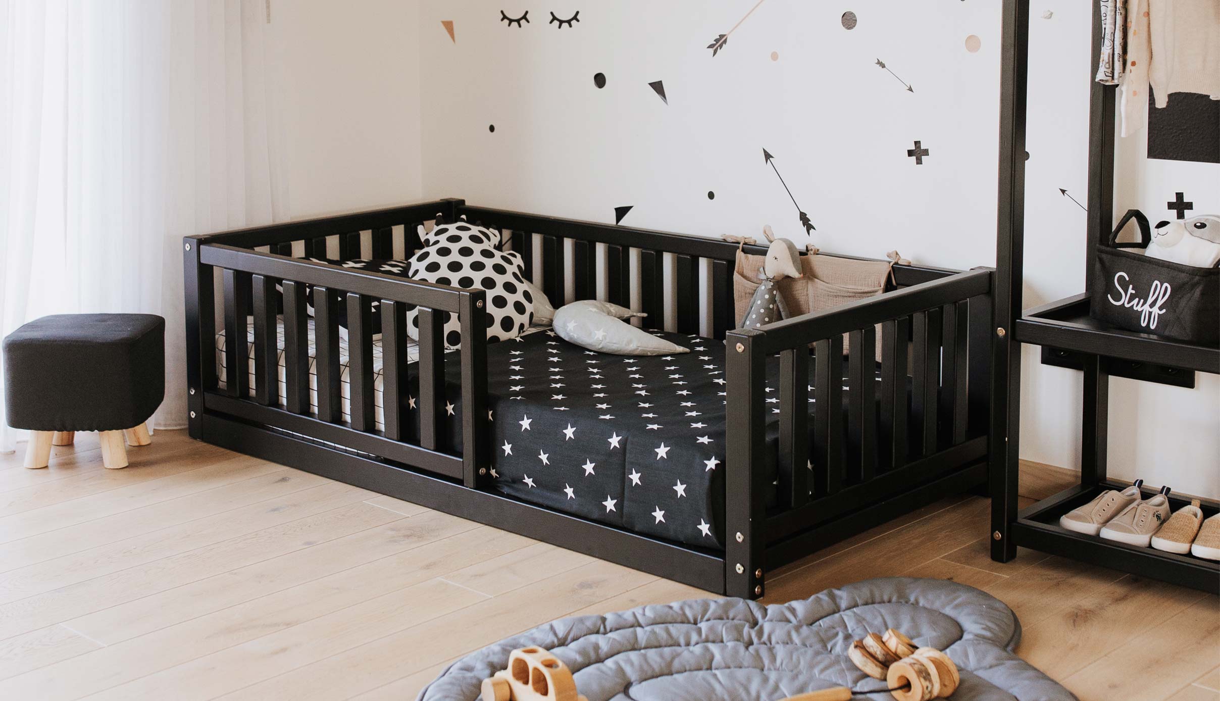A baby's room with a black crib and black and white decor.