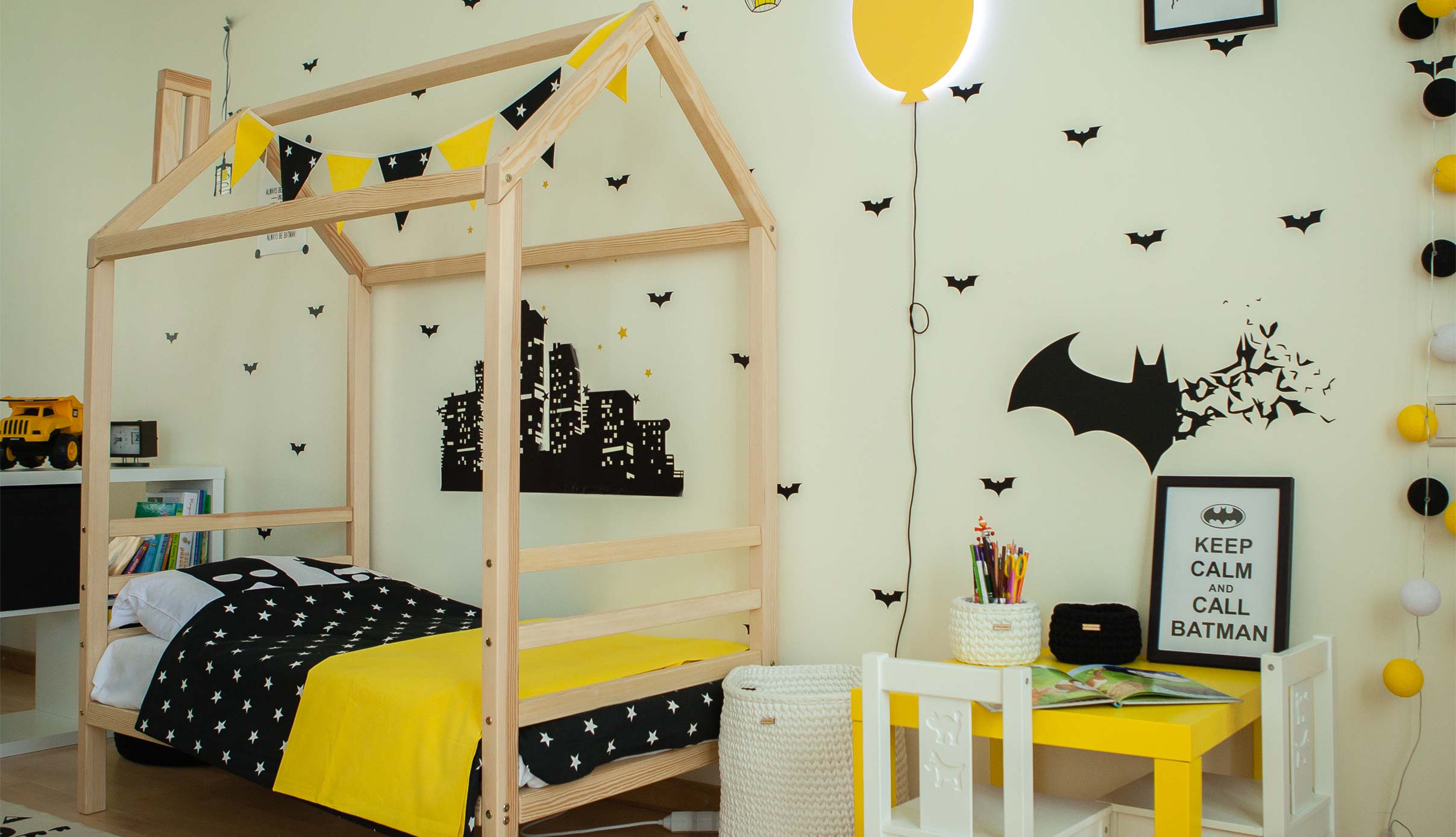 A batman themed bedroom with yellow and black decorations.