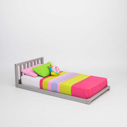 A Sweet Home From Wood 2-in-1 toddler bed on legs with a vertical rail headboard, made from solid pine or birch wood, featuring colorful sheets and pillows. This children's bed is both stylish and comfortable for your child.