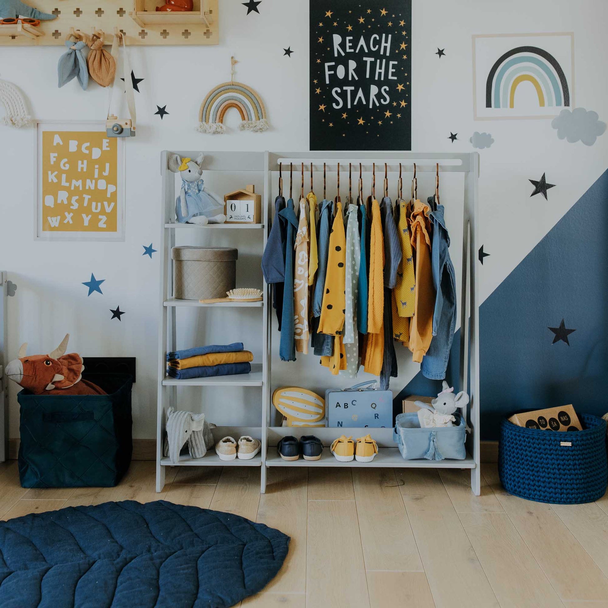 A child's room with an open Sweet Home From Wood children's wardrobe for toddler dress up clothing.