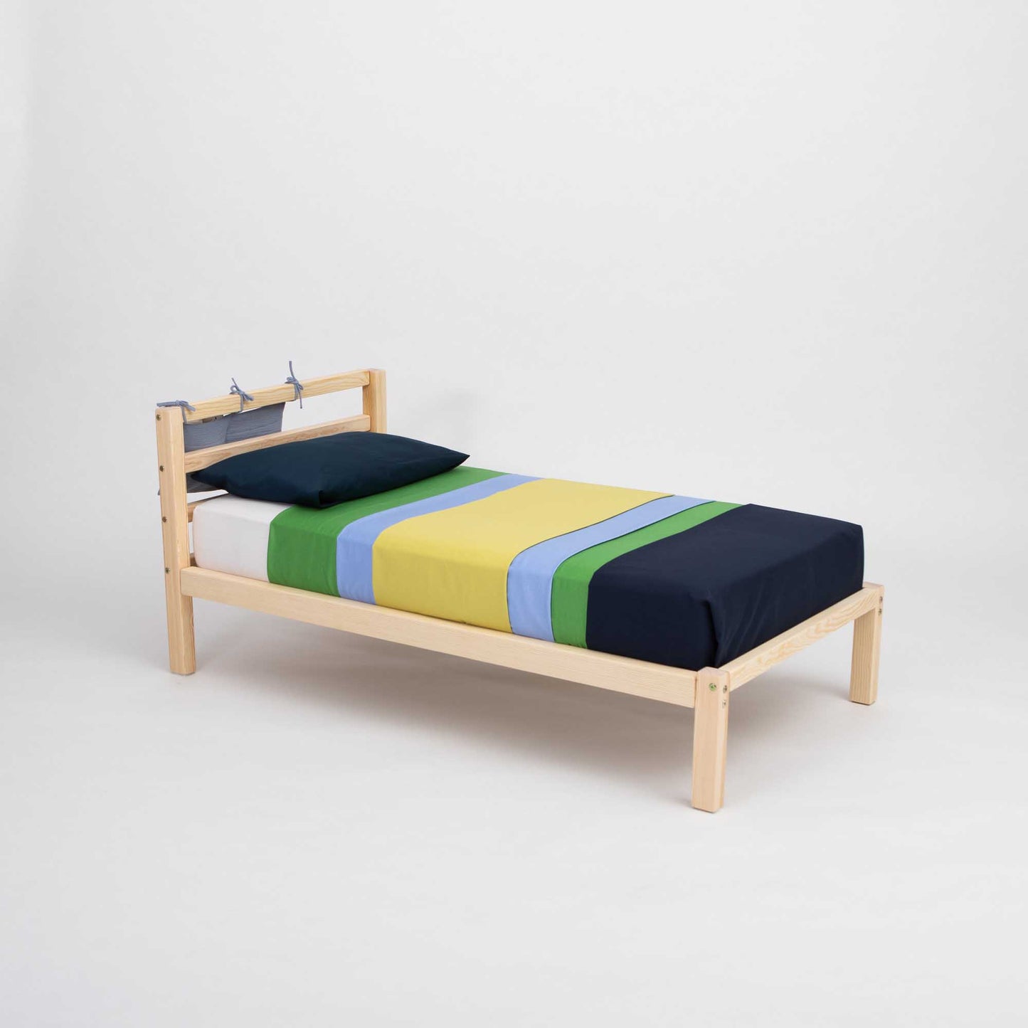 A Kids' bed on legs with a horizontal rail headboard from Sweet Home From Wood, adorned with a colorful striped sheet.