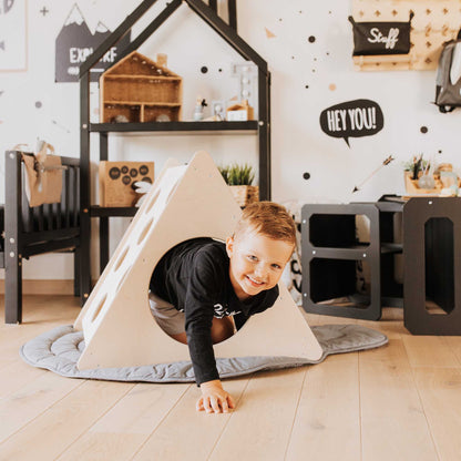 A little boy playing with the Sweet Home From Wood Climbing triangle + Climbing arch + a ramp in his room.