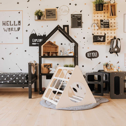 A children's room with a black and white theme, featuring a Sweet Home From Wood Climbing triangle + Transformable climbing gym + a ramp.