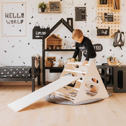 A boy is playing with a Climbing triangle + Transformable climbing gym + a ramp in his room.