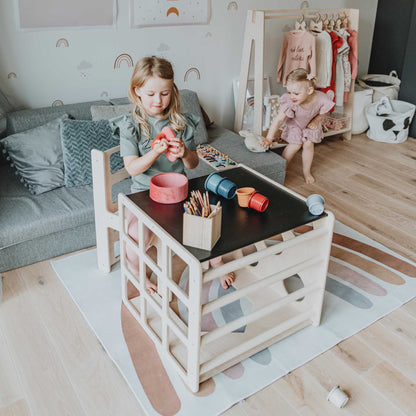 A child is playing with a transformable climbing cube / table and chair + ramp in a living room, exploring their imagination and movement through an indoor climber.