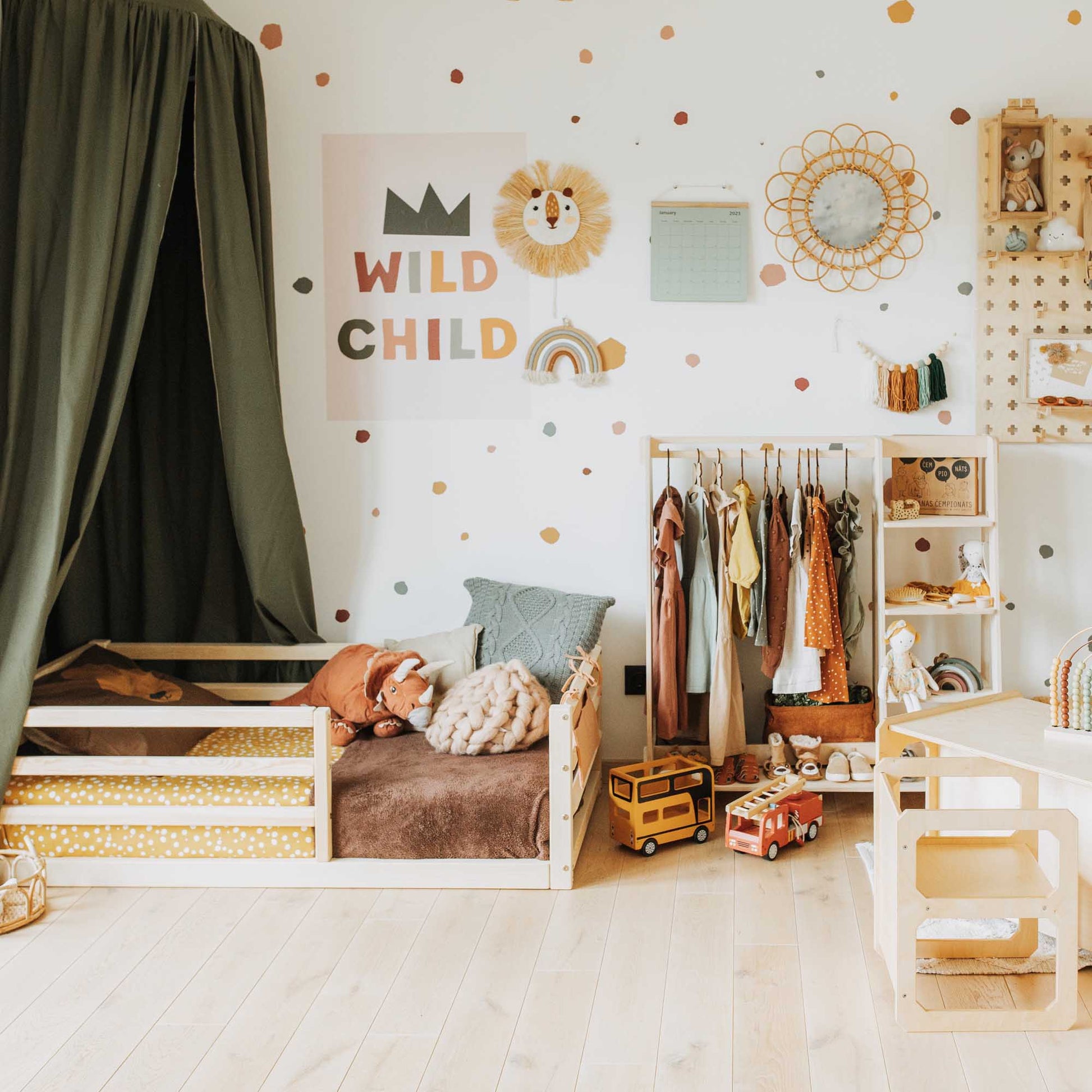 A child's room with a Sweet Home From Wood kids' bed with a horizontal rail fence and a polka dot wall.