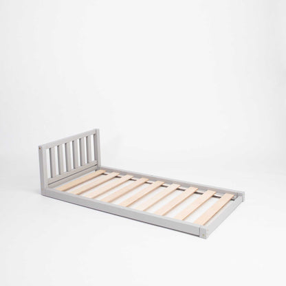 A Sweet Home From Wood 2-in-1 toddler bed on legs with a vertical rail headboard made of solid pine or birch wood with wooden slats on a white background.