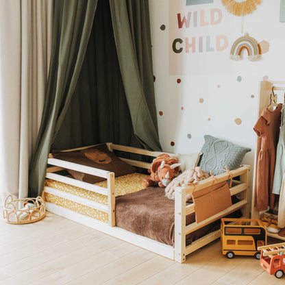 A child's 2-in-1 room with a Sweet Home From Wood transformable kids' bed with a horizontal rail fence and toys.