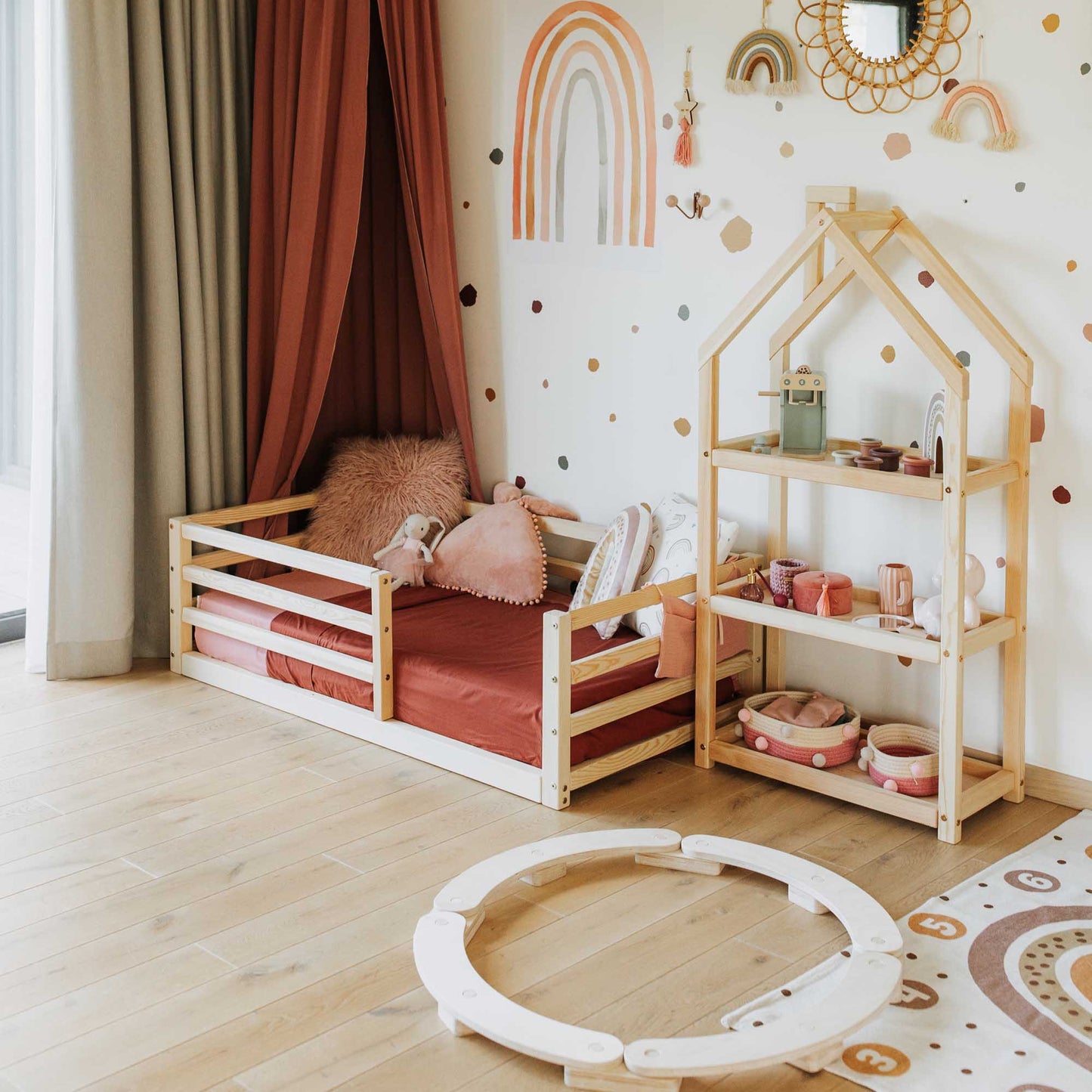 A child's room with a Sweet Home From Wood 2-in-1 transformable kids' bed with a horizontal rail fence, a chair, and a rug.