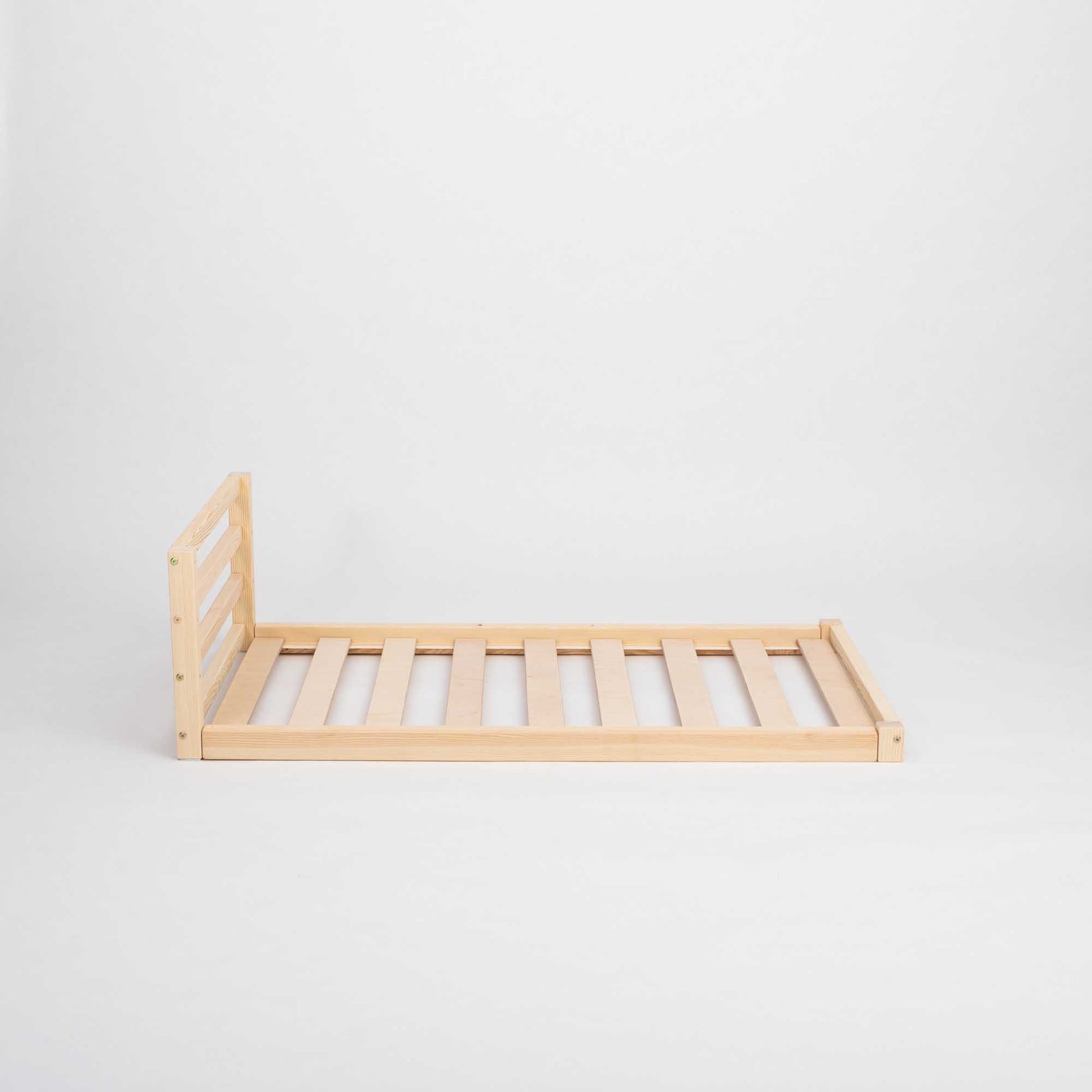 A Sweet Home From Wood solid pine wooden Toddler floor bed with a horizontal rail headboard, with slats on a white background, suitable for children's independent sleeping.