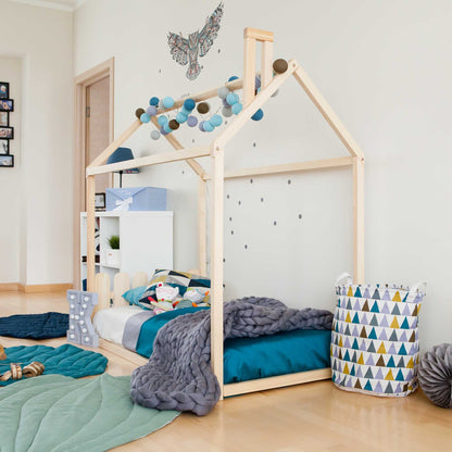 A child's room with a Kids' house-frame bed with a picket fence headboard and toys.