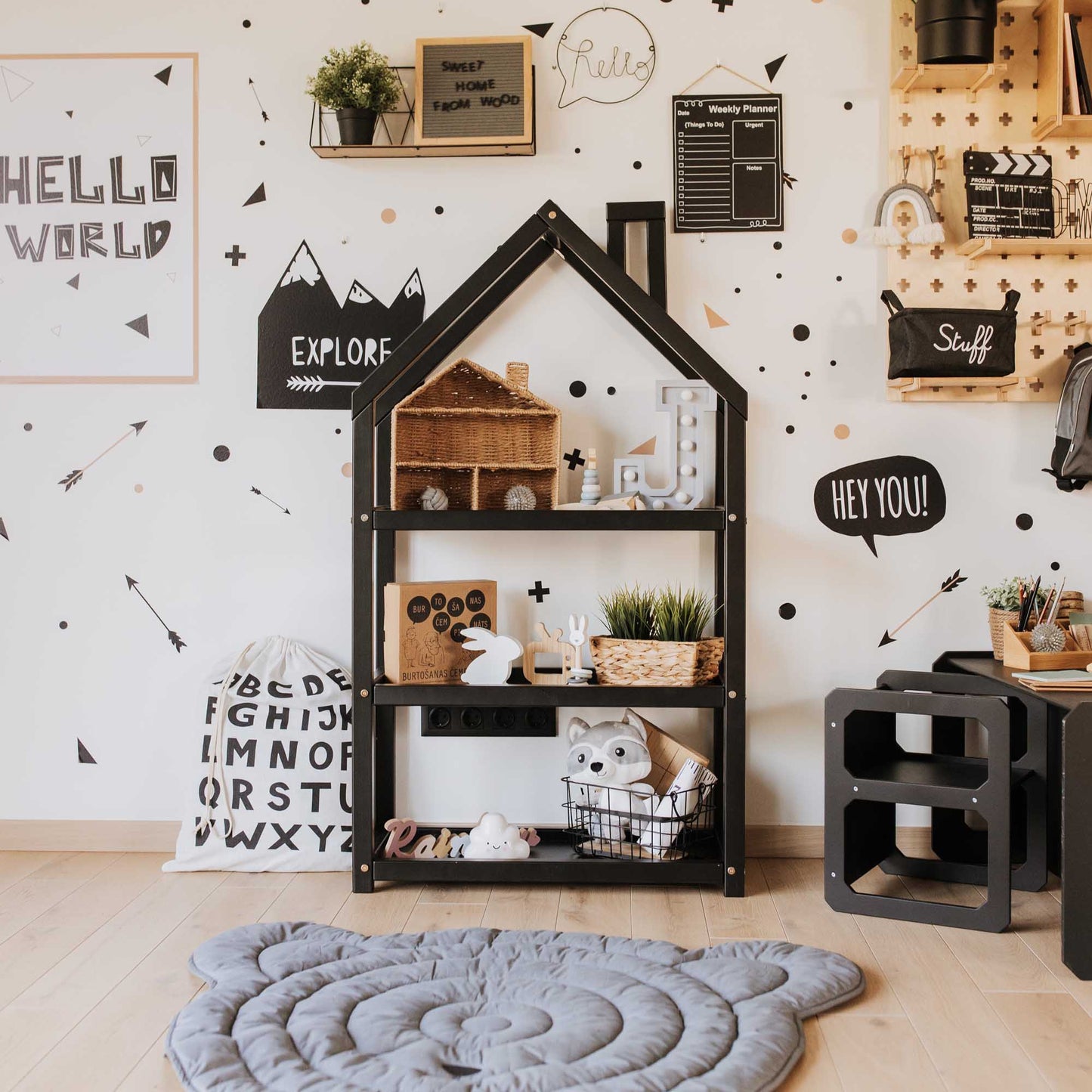 A children's room with a black and white theme, featuring a Sweet Home From Wood house-shaped Montessori toy shelf.