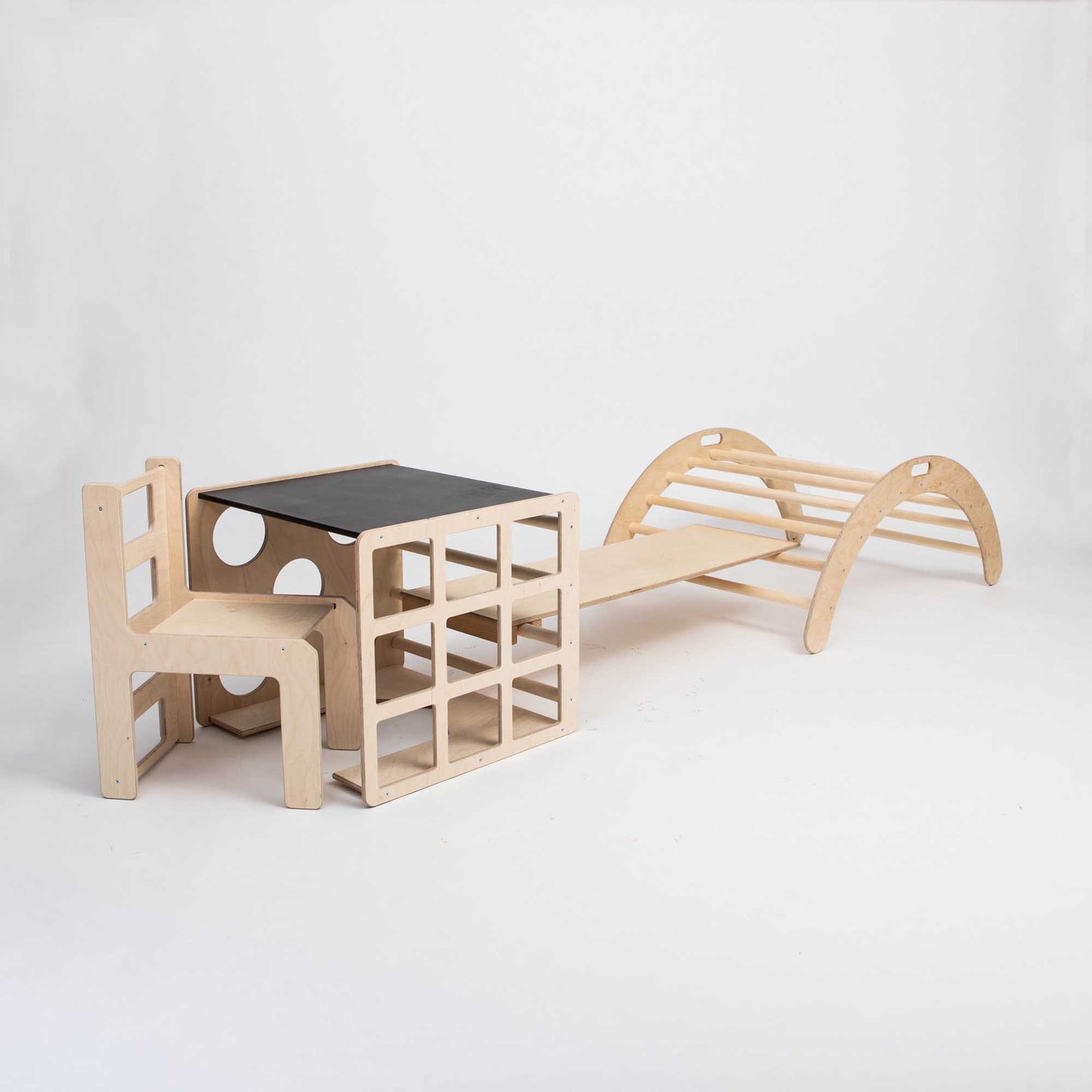 A Sweet Home From Wood wooden chair, a desk, and an activity play set consisting of a Climbing arch, a Transformable climbing cube, a table and chair set, and a ramp.