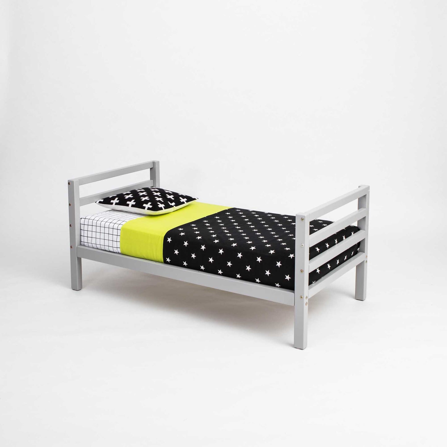 A long-lasting 2-in-1 kids' bed with polka dot sheets and a grey frame from Sweet Home From Wood that grows with the child.