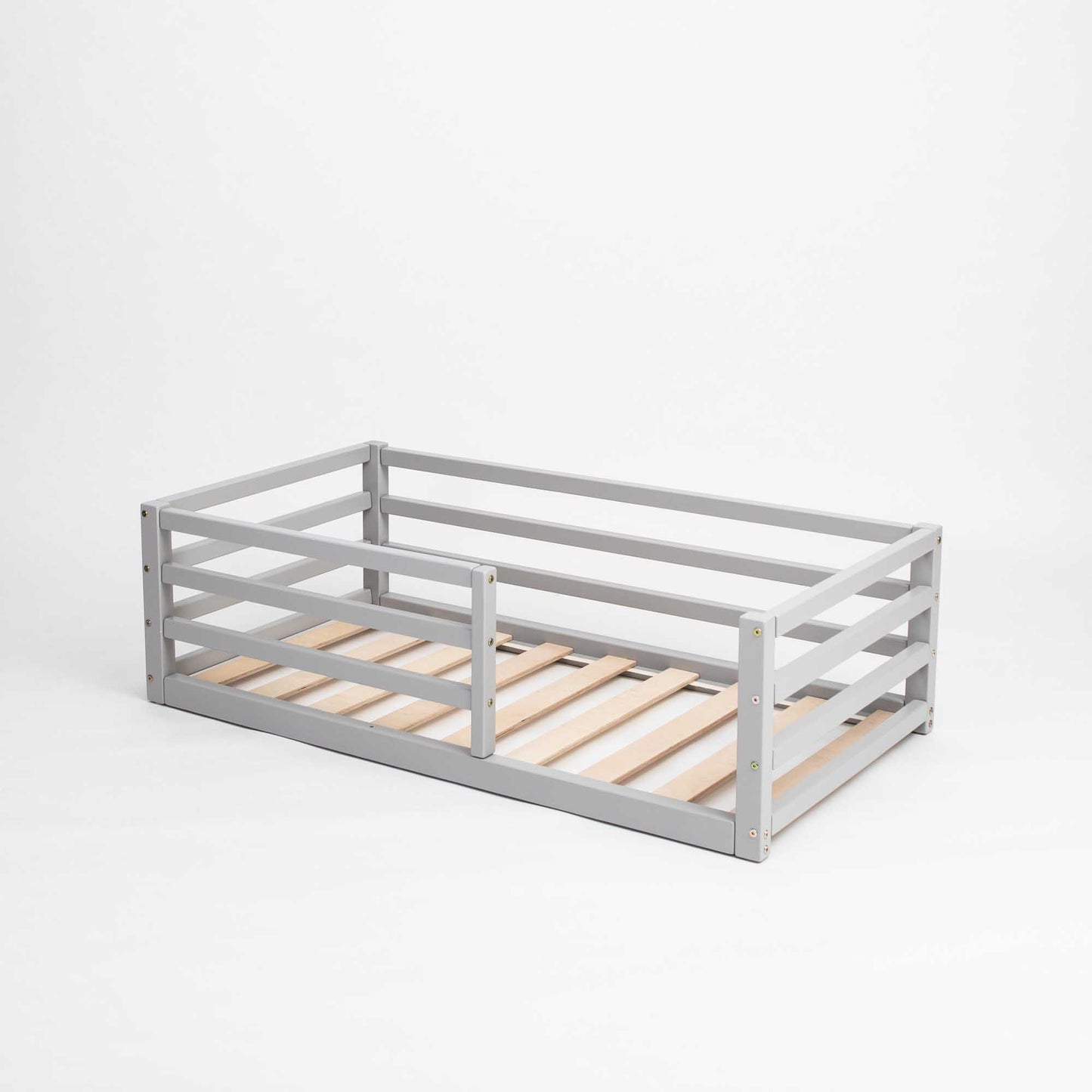 This Sweet Home From Wood floor-level kids' bed with a horizontal rail fence is a transitional piece that encourages independent sleeping with its wooden slats, making it perfect for toddlers.