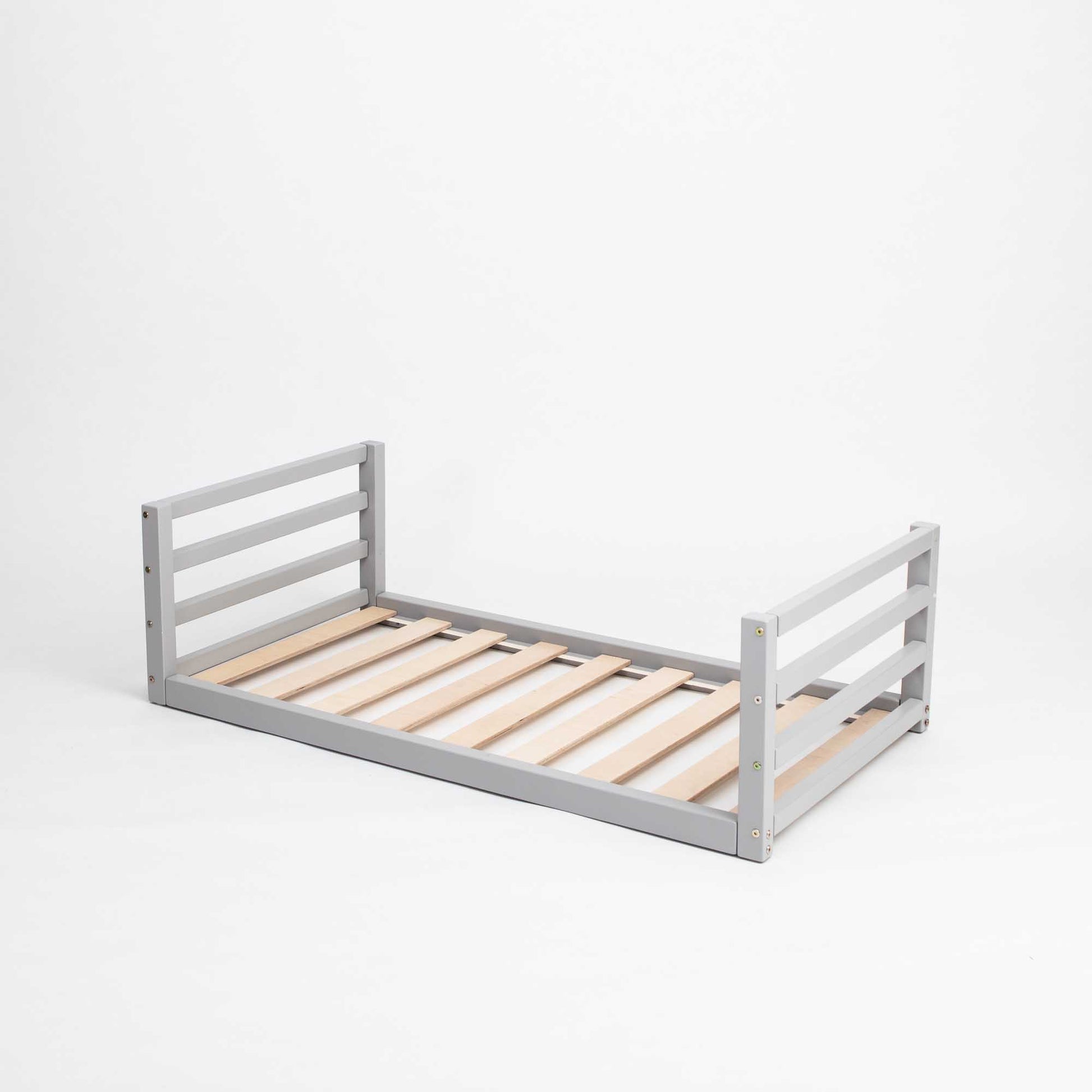 A grey Sweet Home From Wood toddler floor bed with wooden slats on a white background, made of solid pine wood.