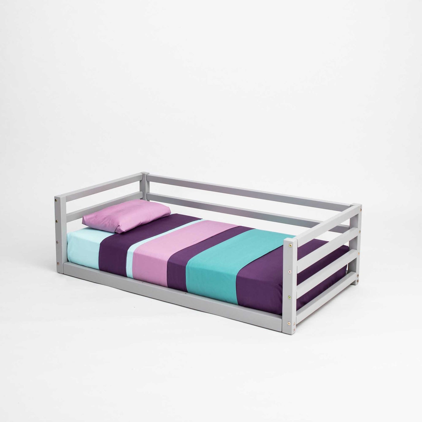 A Children's floor level bed with 3-sided safety rail by Sweet Home From Wood, with a purple, blue, and green striped sheet that is suitable for both boys and girls.
