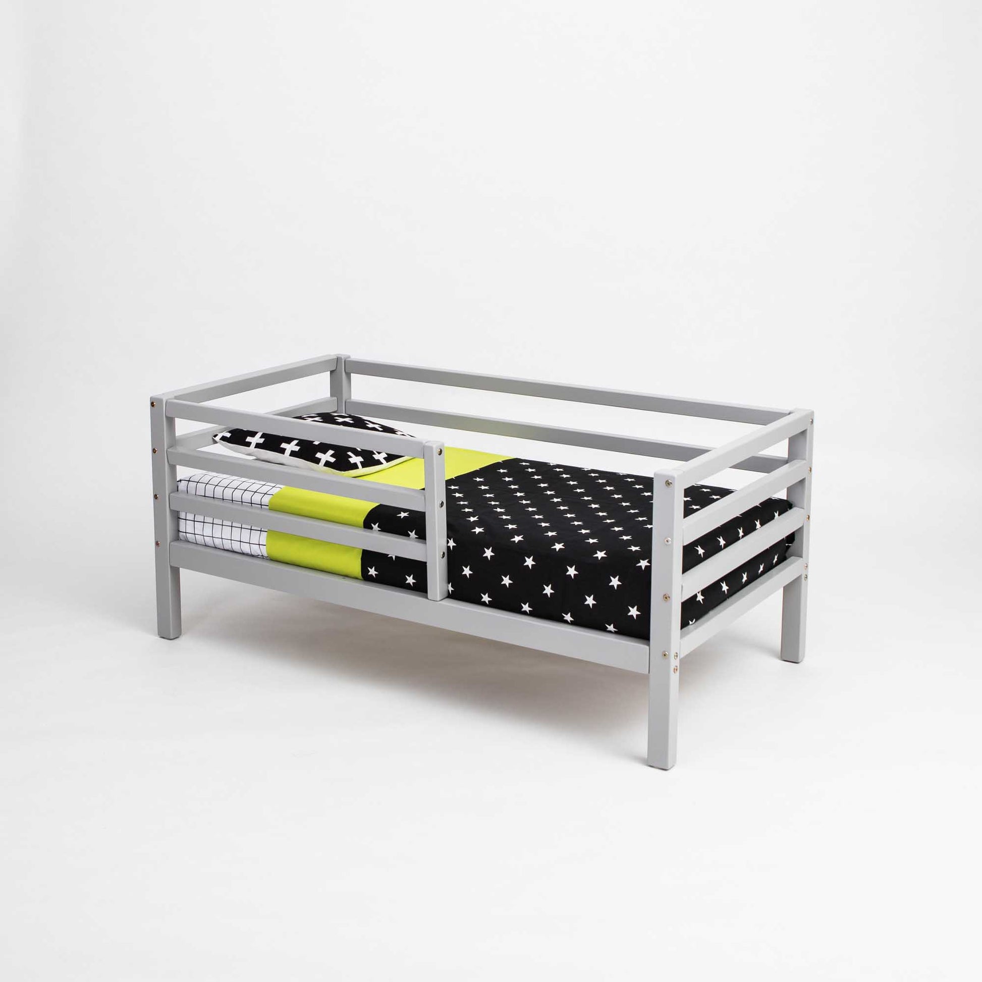 A Sweet Home From Wood Kids' bed on legs with a horizontal rail fence and black and yellow polka dot bedding.