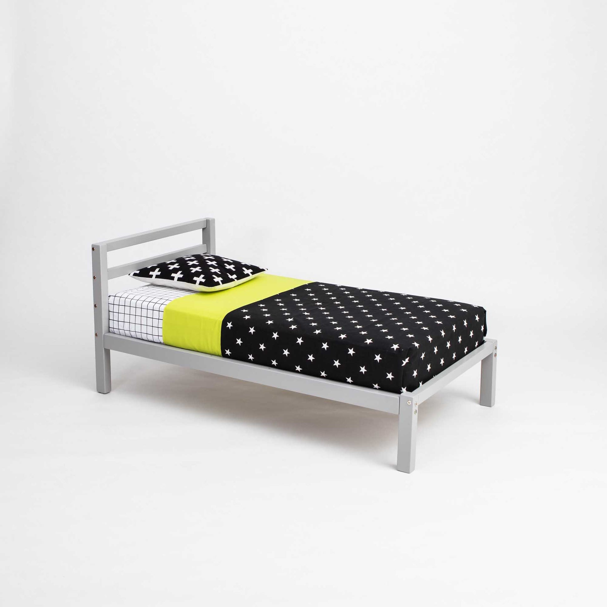 A Sweet Home From Wood convertible bed featuring a 2-in-1 transformable kids' bed with a horizontal rail headboard design, perfect for growing with your child. The stylish grey frame complements the charming polka dot sheets.