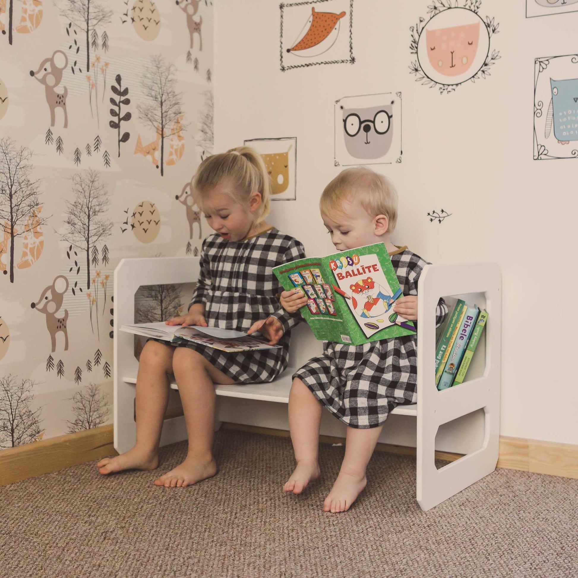 Two children sitting on a Montessori weaning table and chair set, reading books from Sweet Home From Wood.
