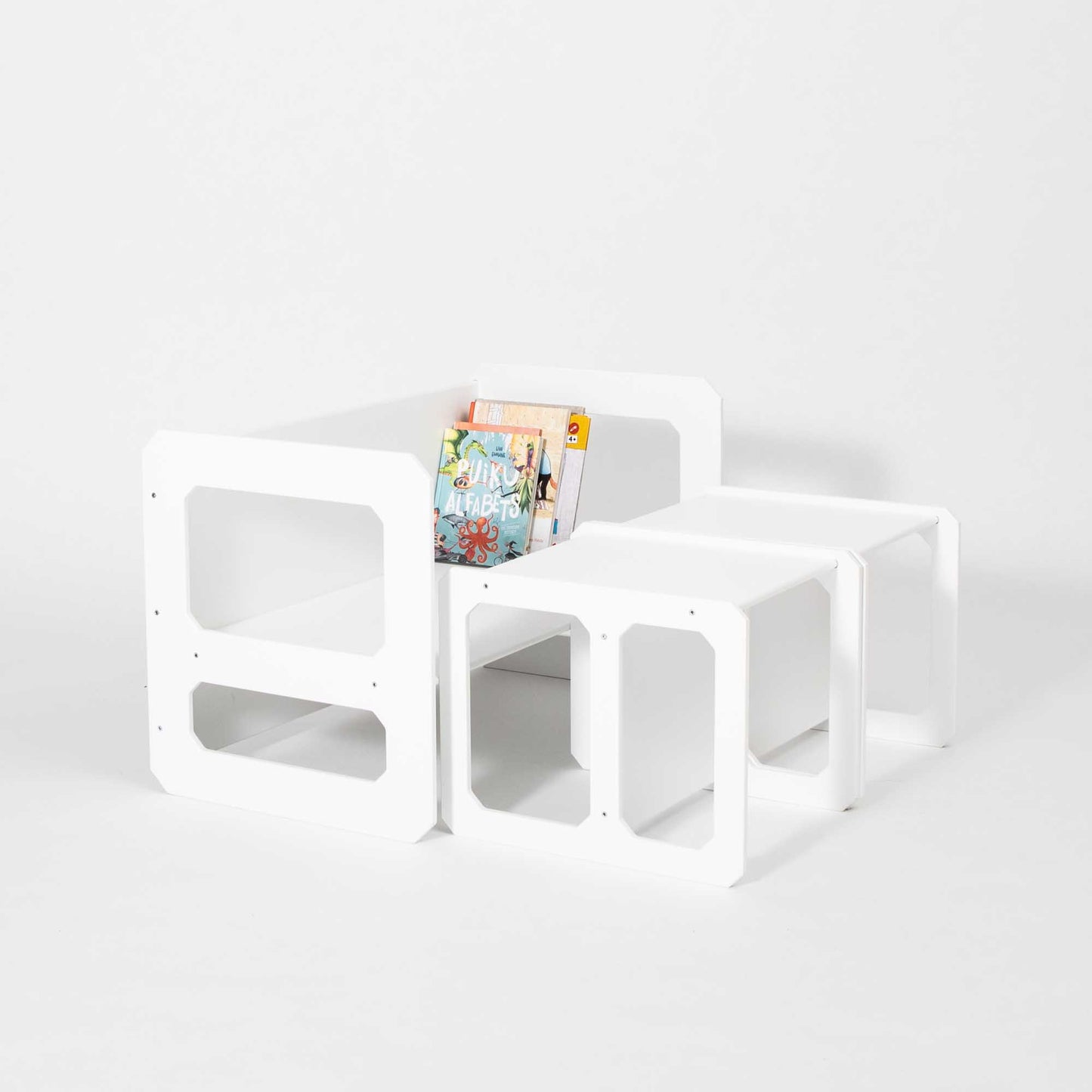 A Montessori weaning table and 2 chair set with books and magazines on it.