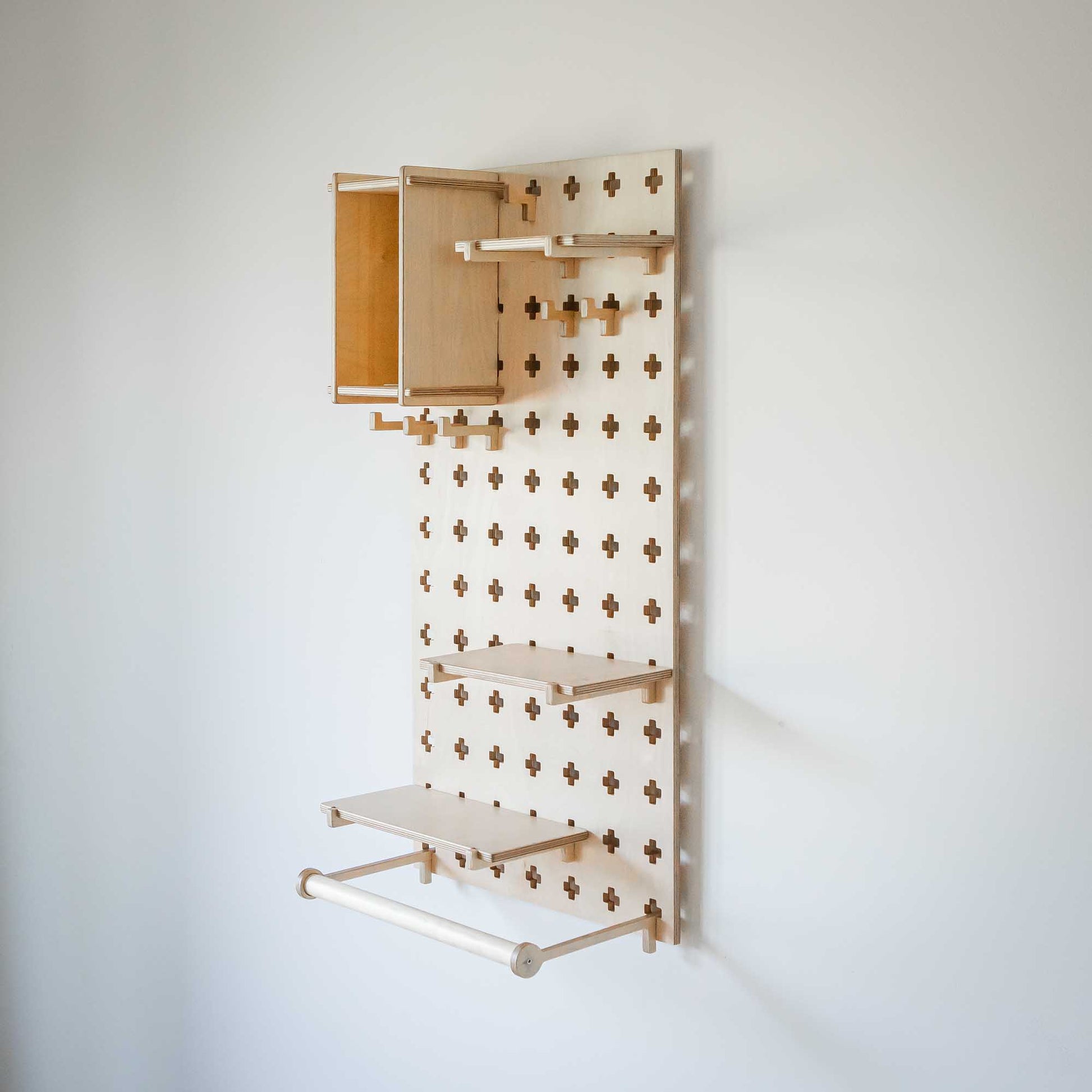 An open storage Sweet HOME from wood wooden shelf with Pegboard with Clothes Hanger hanging on it.