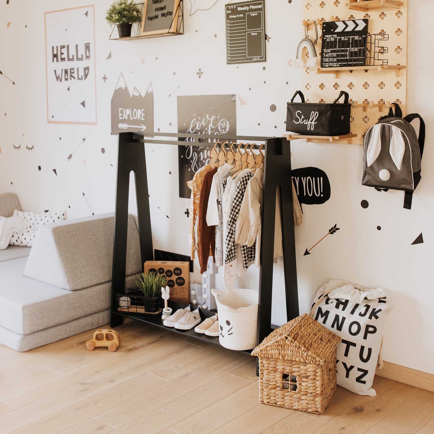 A child's room featuring an open Sweet Home From Wood Kids' clothing rack with black and white decor.