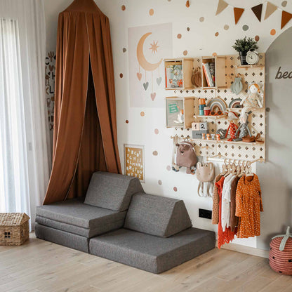 Children's playroom with a gray foam mat, brown canopy, Large Pegboard Shelf with Clothing Rack holding toys, books, and clothes, along with decorative wall elements. The customizable layout and organizer ensure a warm and inviting atmosphere.