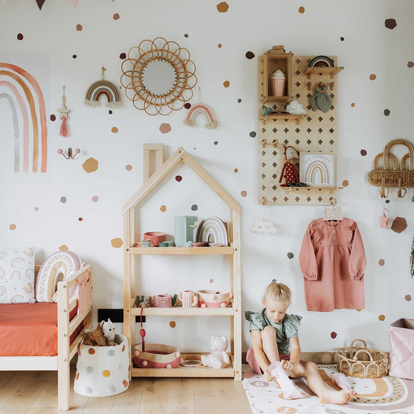 A child's room with polka dot walls and Sweet HOME from wood Floating Shelves Pegboard.