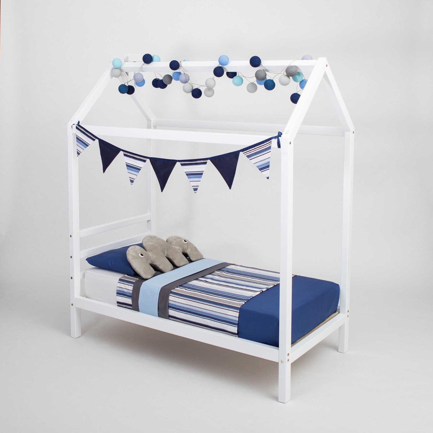 A Kids' house bed on legs with a headboard bed with blue and white stripes and bunting.