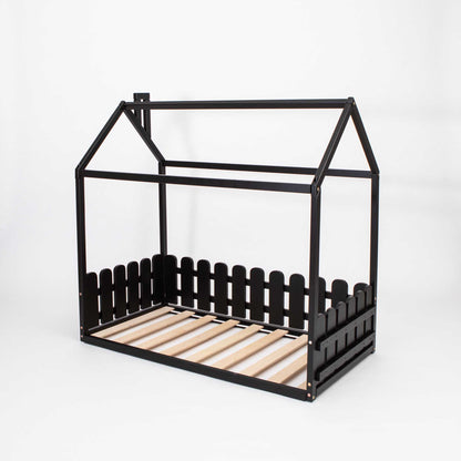 A black Floor house-frame bed with 3-sided picket fence rails and wooden slats.