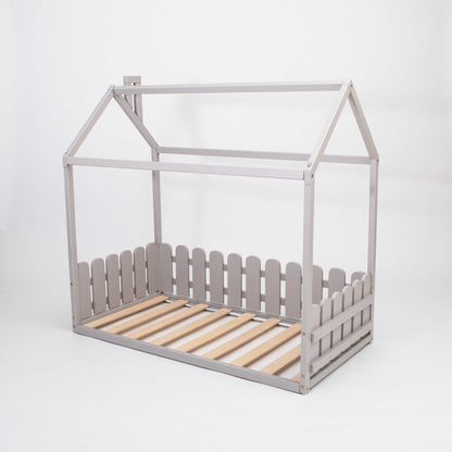 A Floor house-frame bed with 3-sided picket fence rails, suitable as a montessori floor bed for toddlers or a floor level bed for kids.
