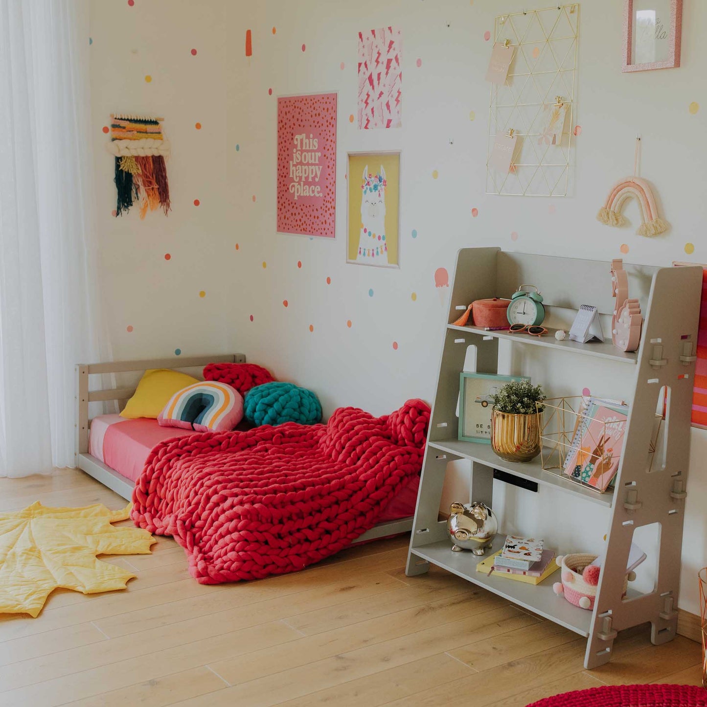 A child's room with a Sweet Home From Wood toddler floor bed with a horizontal rail headboard for girls and a colorful rug.