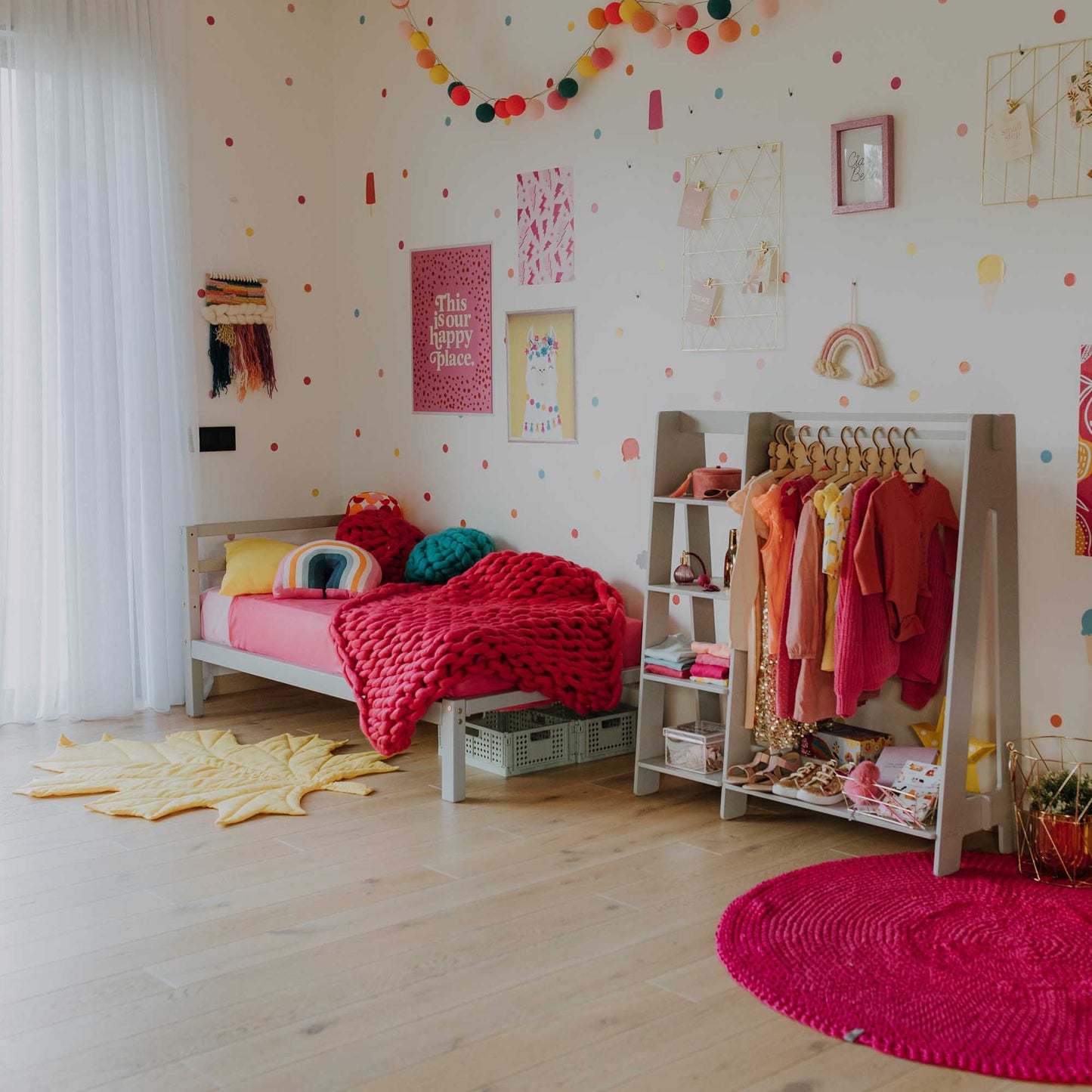 A Sweet Home From Wood kids' bed on legs with a horizontal rail headboard in a girl's room, complete with a bedside table.