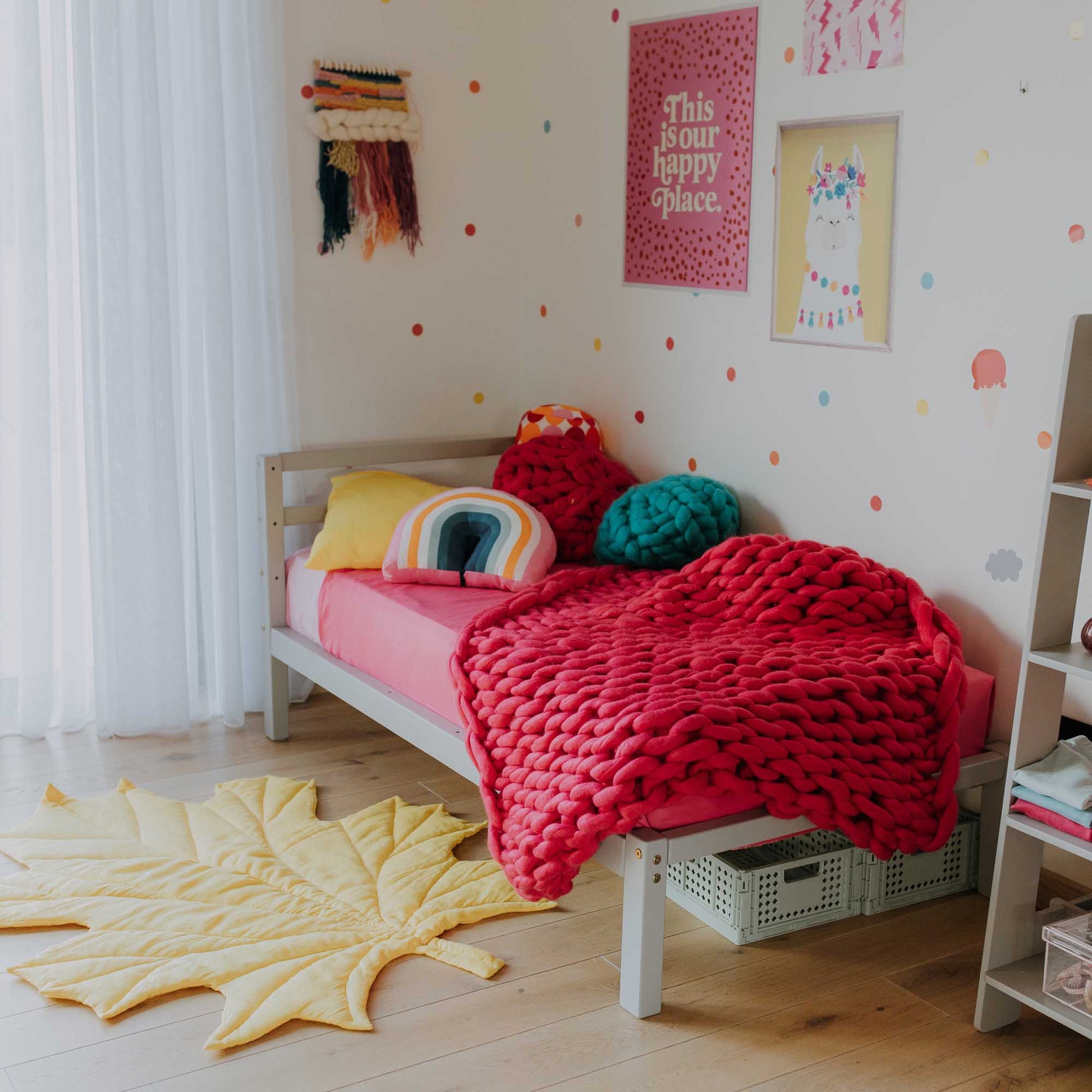 A girl's room with a colorful and versatile Sweet Home From Wood 2-in-1 transformable kids' bed with a horizontal rail headboard.