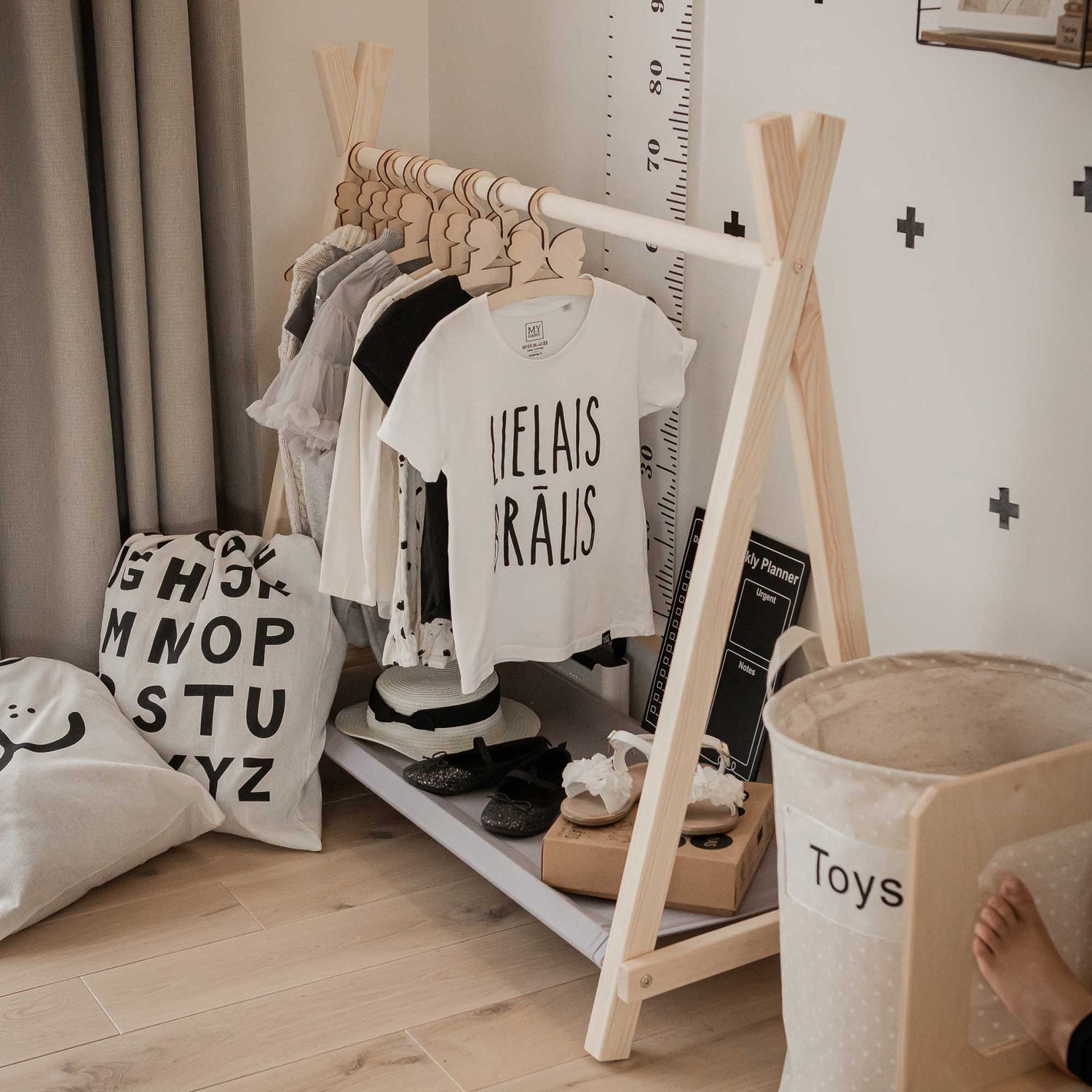 A child's room with a wooden teepee and teddy bears.