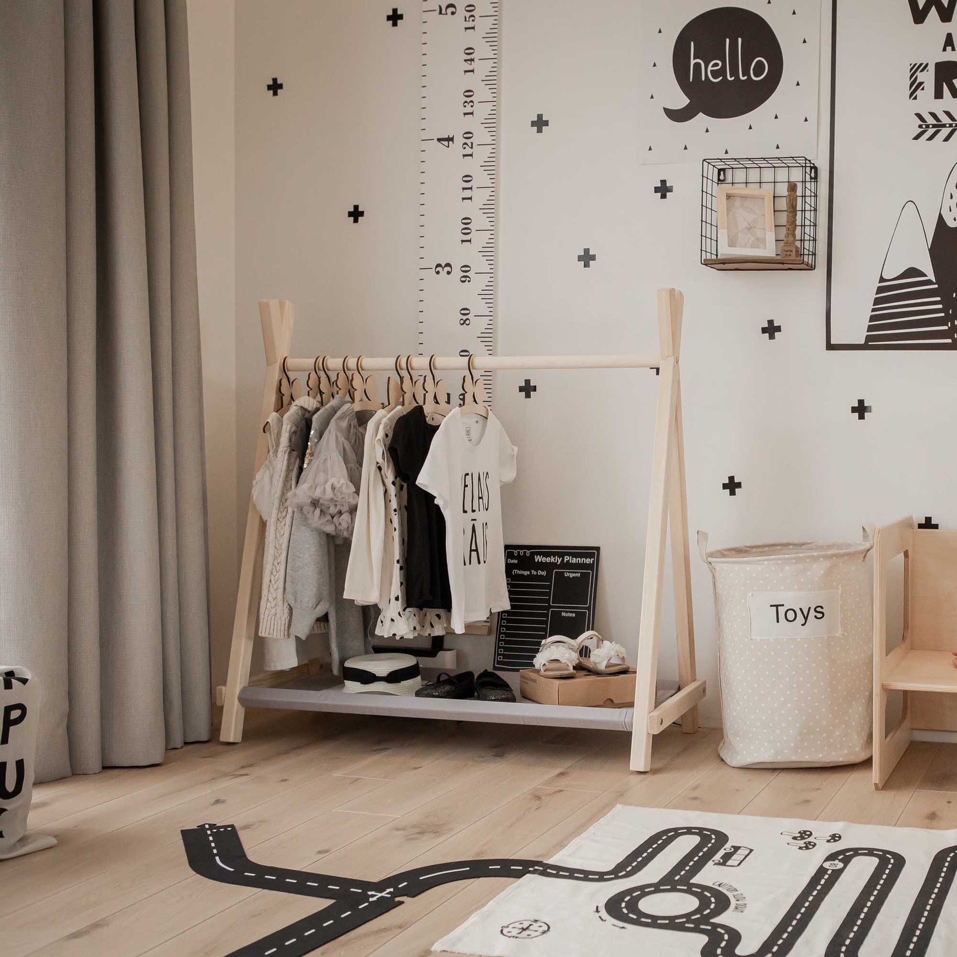A toddler's room with a black and white theme featuring a Sweet Home From Wood Kids' clothing rack with storage.