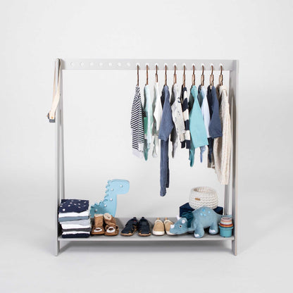 A-frame kids' clothing rack from Sweet Home From Wood are neatly hanging on an open wardrobe.