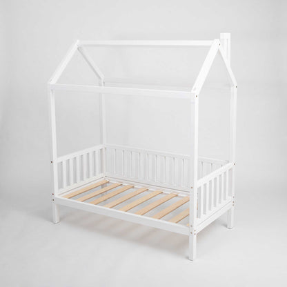 A raised white raised house bed on legs with 3-sided rails.